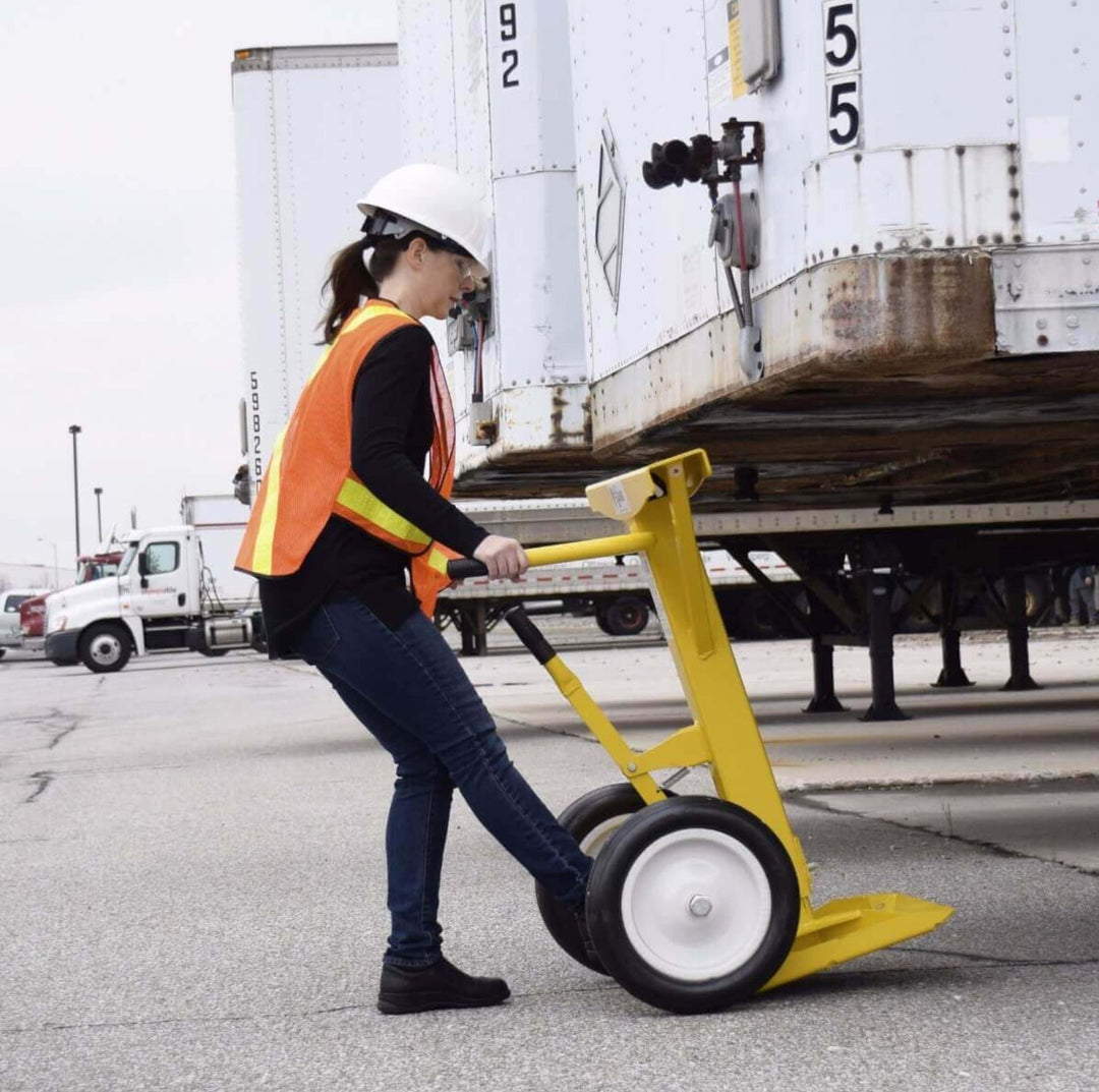 Warehouse worker positioning a trailer support stand