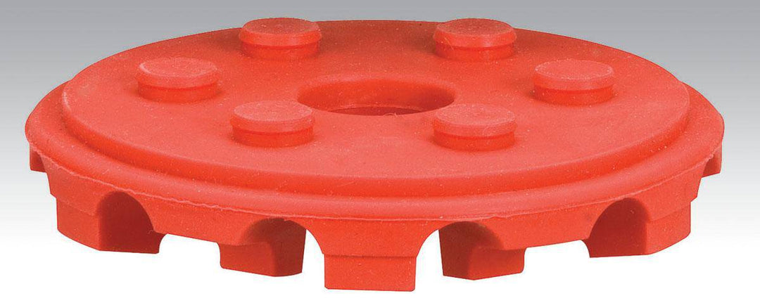 Dynabrade 92297 4-inch diameter red Tred eraser disc on backup pad, used for surface finishing and cleaning.